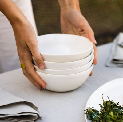Person creating a Dreamy tablescape with hand-finished, bowls that are made from natural stoneware crockery