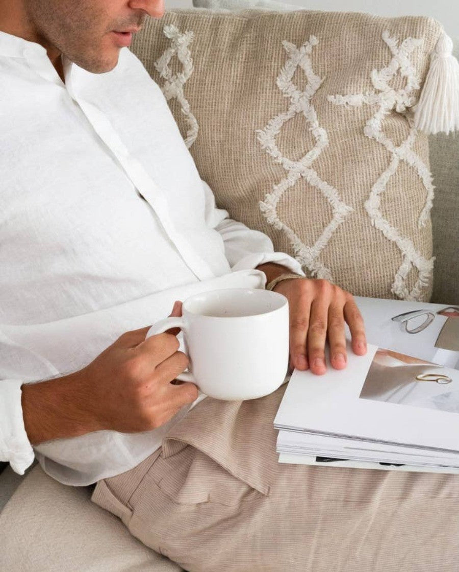 Man drinking from a speckled white ceramic mug from Fable dinnerware brand.