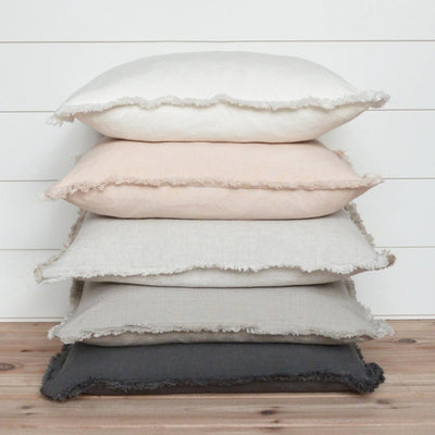 Fringed pillows stacked in variety of colors