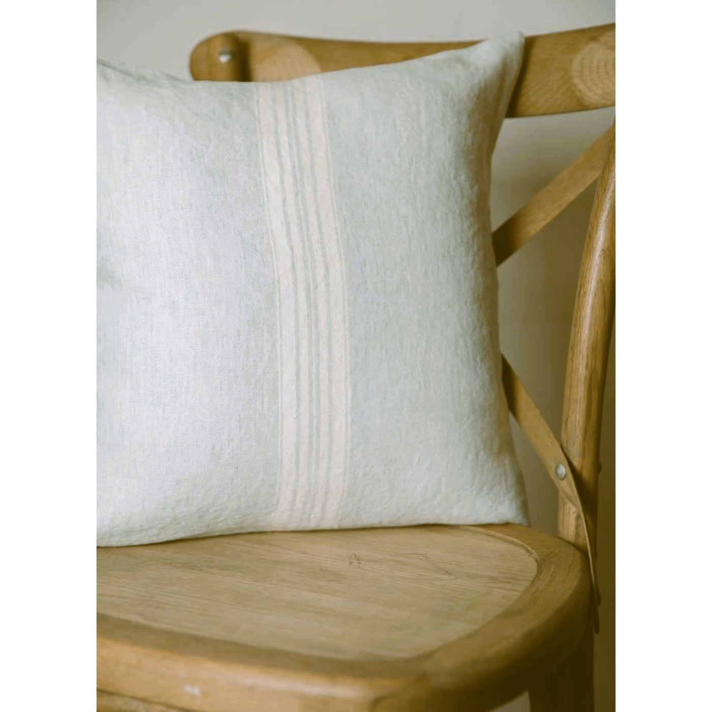 Maison Linen Pillow, Mineral Blue with White stripes. Premium down alternative insert included. On wooden chair.