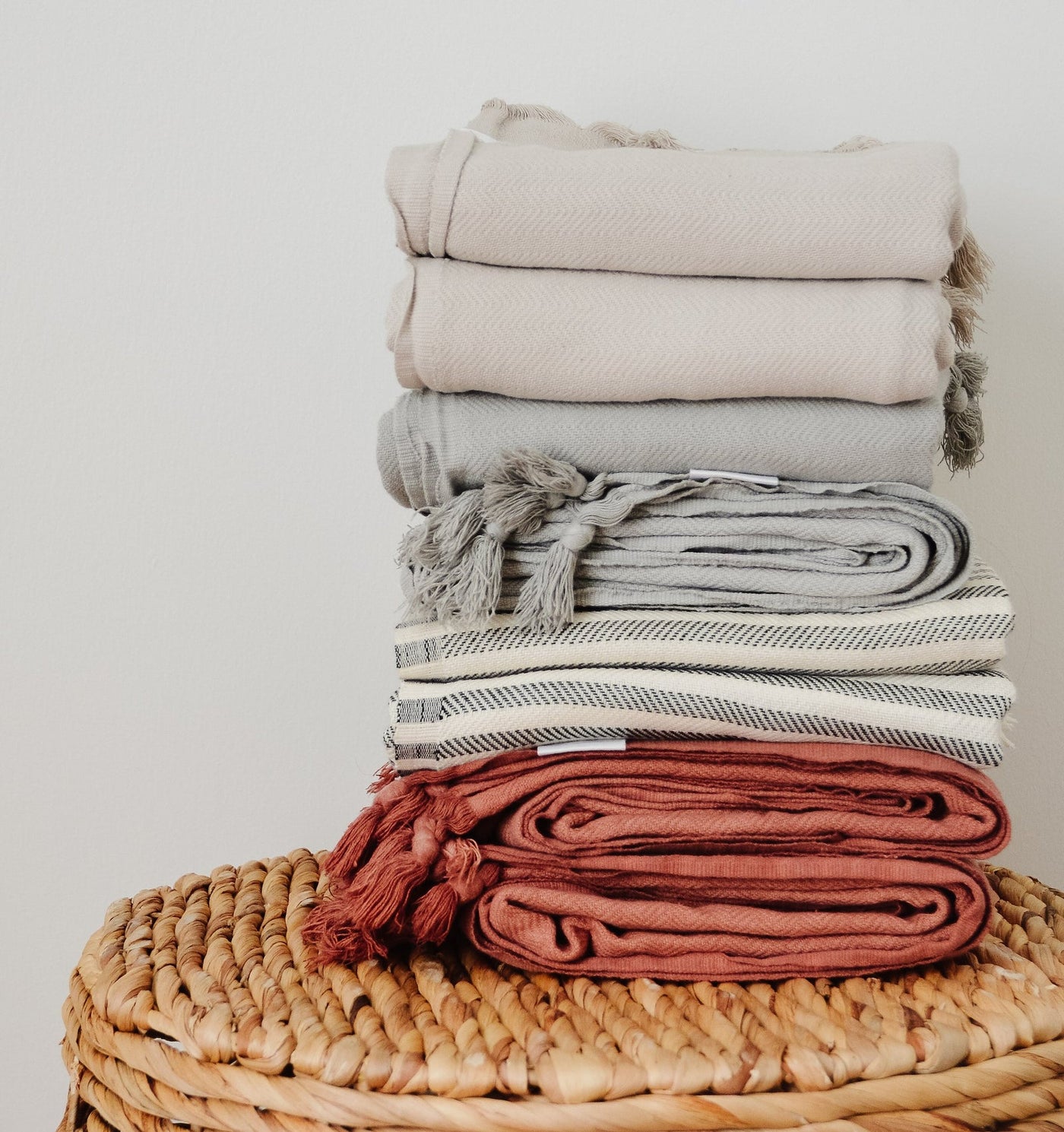 Turkish Towels: by House of Jude, folded and stacked in different colors on table. Oversized 63"x39.4", Available at Avalon Willow Home.