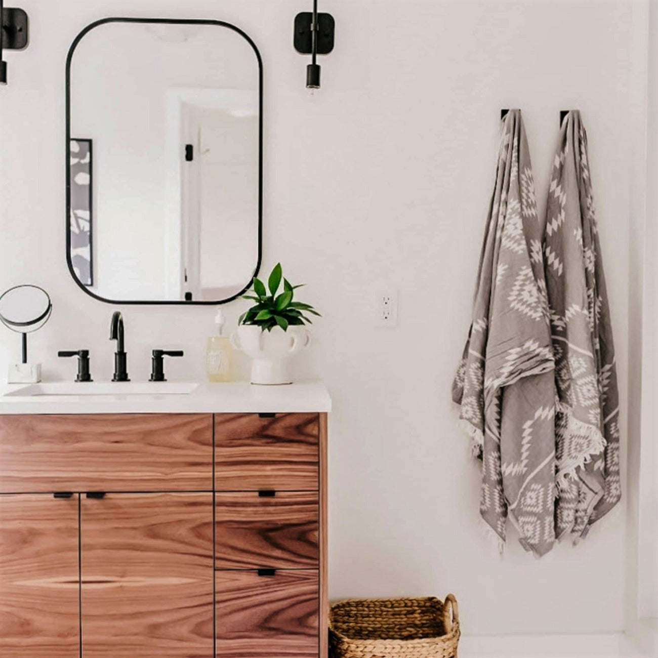 Grey reversible towel with a geometric design hanging in a bathroom.