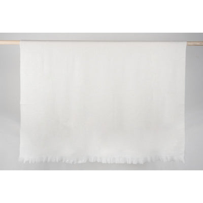 coconut white alpaca throw Super-Soft with fringed edges hung over wooden rod