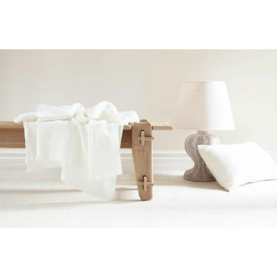 Stone-washed Lipari Linen Throw With Fringes, Rustic White: On stool beside lamp