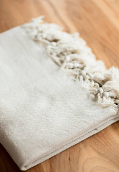 Turkish Towel, Oat: Folded on table. Made with 100% Turkish cotton, with tassels. Size: 63" x 39.4" oversized bath. Brand: by House of Jude. Shop at Avalon Willow Home
