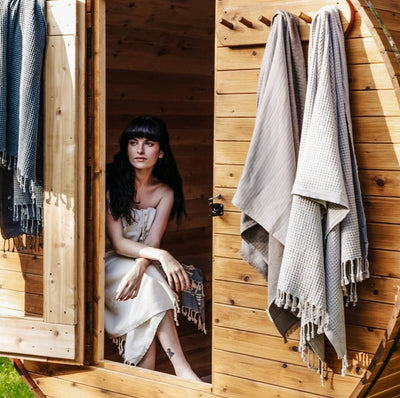 Woman in sauna full body wrapped in clay color Pokoloko Stonewashed Waffle weave Towel