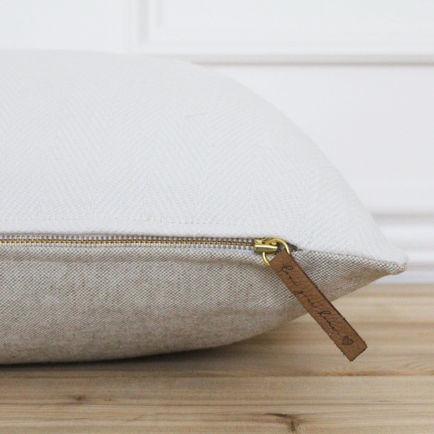 Gold Zipper pillow, Ava Herringbone. Front is white, back is natural fla. Has leather zipper tag