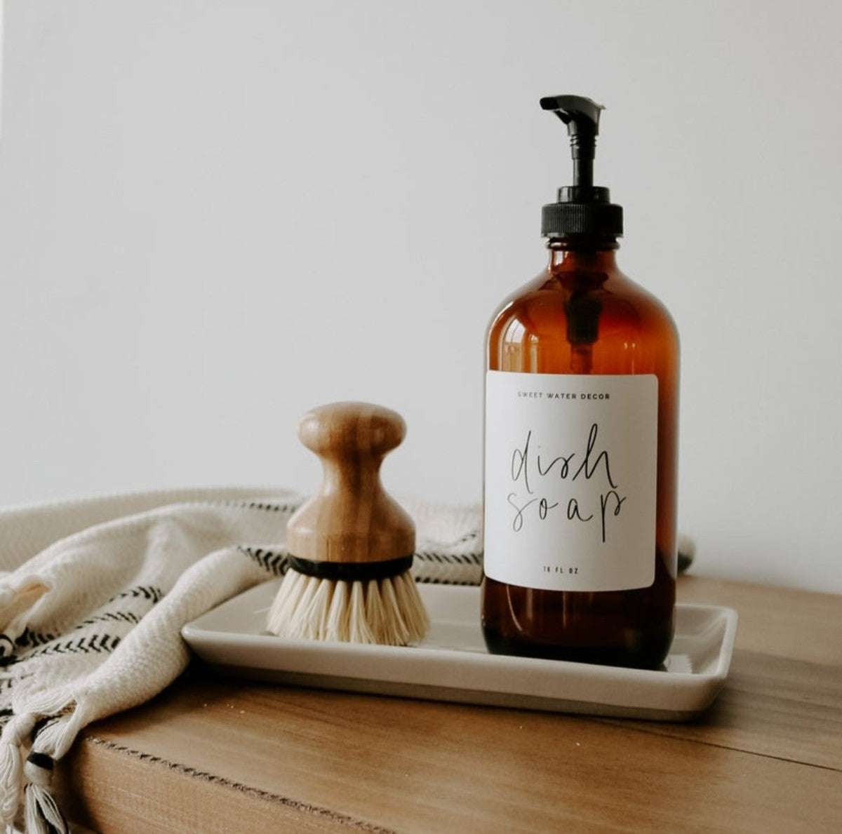 Amber Glass Dish Soap Bottle with brush on tray.