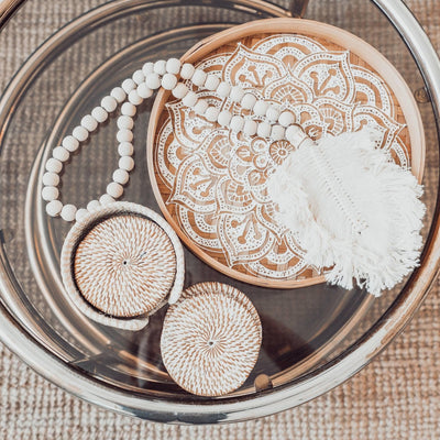 Beaded garland with feather tassel displayed in tray