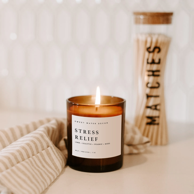Non-Toxic Soy Candle beside matches and towel.  Scent is called Stress Relief